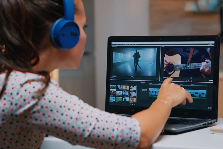 A young woman editing a music video on her laptop.