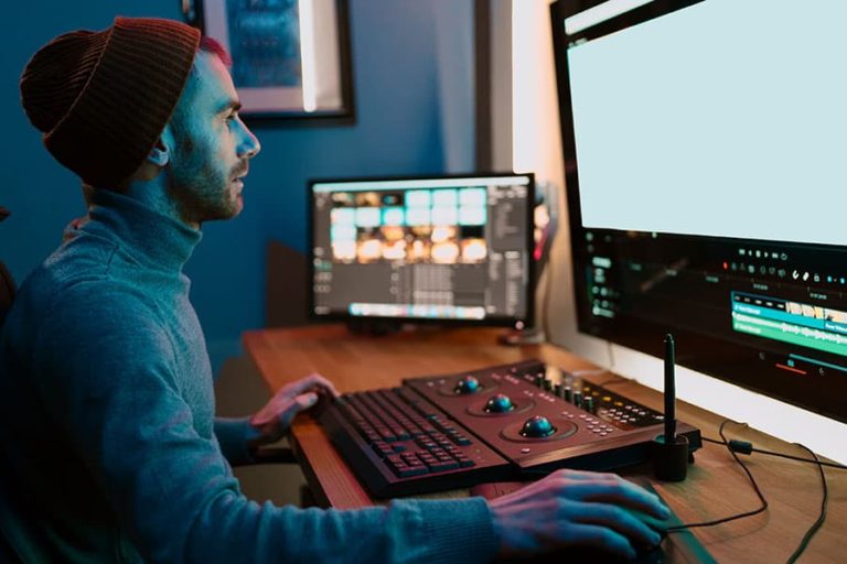 A video editor working with high-end computer equipment.